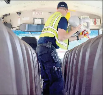  ?? Keith Bryant/The Weekly Vista ?? Firefighte­r-paramedic Greg Mills retrieves an inflatable patient from a school bus.