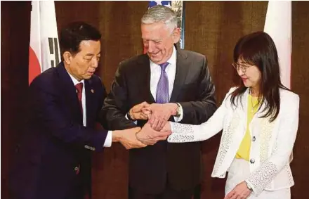  ?? REUTERS PIC ?? South Korean Defence Minister Han Min-koo (left) showing United States Secretary of Defence Jim Mattis (centre) and Japanese Defence Minister Tomomi Inada how to do a handshake during a trilateral meeting on the sidelines of the Shangri-La Dialogue in...