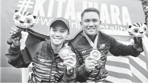  ?? — Gambar Bernama ?? PANAHAN EMAS: Fatin Nurfatehah (kiri) bersama Mohd Juwaidi meraikan kejayaan meraih pingat emas dalam acara memanah (Compound) Berpasukan Campuran, semalam.