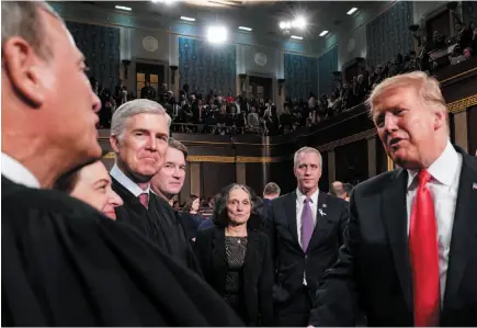  ?? AP PHOTO ?? U.S. President Donald Trump talks to Supreme Court Chief Justice John Roberts while leaving the House chamber after giving his State of the Union address to a joint session of Congress on Tuesday in Washington, DC.