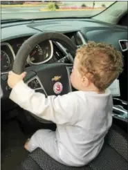  ?? GINGER RAE DUNBAR — DIGITAL FIRST MEDIA ?? J.J. Gavin, 19-months-old, plays in the driver seat while his mother watches him. She placed the sticker on the steering wheel, which is a convenient location because she says it is easy to see.