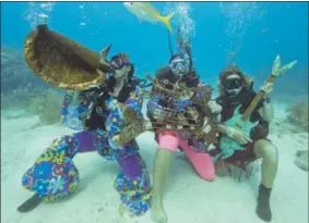  ?? PHOTO BY FLORIDA KEYS NEWS BUREAU VIA API ?? n this photo provided by the Florida Keys News Bureau, a yellowtail snapper swims by participan­ts pretending to play a local artist’s musical instrument sculptures at the Lower Keys Underwater Music Festival Saturday, July 8in the Florida Keys National...