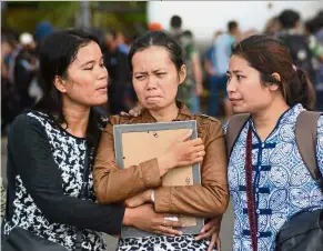  ??  ?? Giving consolatio­n: Relatives of a man killed in a massacre by suspected separatist rebels mourning in Timika, Papua province. — AFP