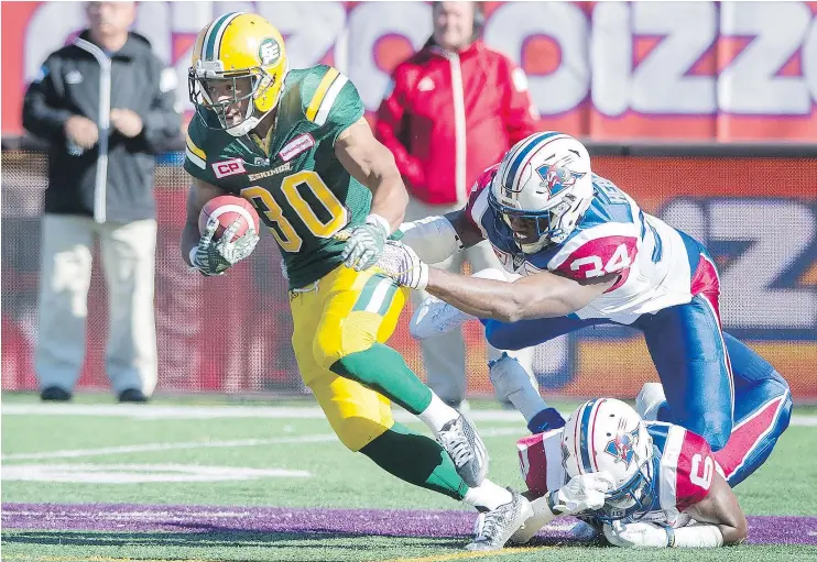  ?? — THE CANADIAN PRESS ?? Edmonton Eskimos’ John White breaks away from the Alouettes’ Kyries Hebert, centre, and Ramon Taylor during game in Montreal on Monday.