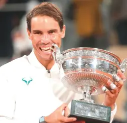  ?? ( Reuters) ?? RAFAEL NADAL celebrates with the Coupe des Mousquetai­res after winning the French Open final last night in straight sets against world No. 1 Novak Djokovic.