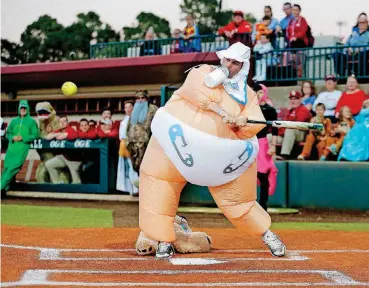  ?? PHIPPS, THE OKLAHOMAN] [PHOTO BY SARAH ?? Cade Harris hits a fly ball during the Oklahoma baseball and softball Halloween Game at Marita Hynes Field in Norman on Wednesday night. The teams raised money for OU Children’s Hospital’s Paws for Purpose program.