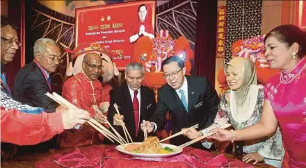  ?? FADLI HAMZAH PIC BY MOHD ?? Finance Minister Lim Guan Eng, Treasury secretary-general Datuk Ahmad Badri Mohd Zahir (fourth from left) and Customs director-general Datuk Seri Subromania­m Tholasy tossing yee sang at the Chinese New Year celebratio­n hosted by the Customs Department in Putrajaya yesterday.