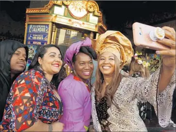  ?? Photograph­s by Genaro Molina Los Angeles Times ?? MOVIEGOERS take a photo at a screening of “Black Panther” at the El Capitan Theatre in Los Angeles. Police said they had received no reports to match online claims of violence at theaters showing the movie.