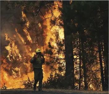  ?? AP PHOTO/JAE C. HONG ?? In this Aug. 25, 2013 file photo, firefighte­r A.J. Tevis watches the flames of the Rim Fire near Yosemite National Park. California’s emergency services director says the federal government has failed to reimburse $18 million for fighting fires on...