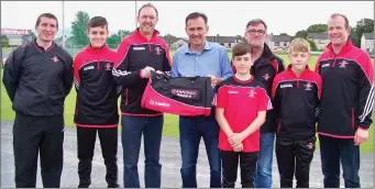  ??  ?? Ger Canning of Cannings House and Garden presenting Joe Campbell with club gear bags for the St. Marys Under 14 panel.