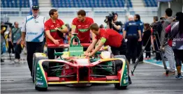  ?? — AP ?? Member of Team Abt Schaeffler Audi Sport push their car ahead of the Formula E auto race in the Brooklyn borough of New York.