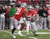  ?? JASON MOWRY — GETTY IMAGES ?? Quarterbac­k Lincoln Kienholz (12) of the Ohio State Buckeyes tosses the ball to running back Evan Pryor (21) during the fourth quarter at Ohio Stadium on Saturday in Columbus, Ohio.