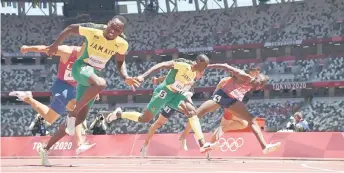  ?? — AFP photos ?? Jamaica’s Hansle Parchment (le ) crosses the finish line to win ahead of second-placed USA’s Grant Holloway (right) and third-placed Jamaica’s Ronald Levy (centre) in the men’s 110m hurdles final.