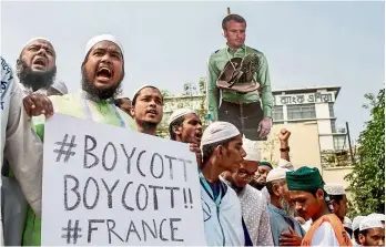  ??  ?? Taking to the
streets: Supporters and activists of the Islami Andolan Bangladesh carrying a cutout of Macron with a garland of footwear around it as they protest in Dhaka, Bangladesh. Thousands of protesters marched through Dhaka yesterday calling for the boycott of French products and to denounce Macron for his comments over a cartoon of the Prophet.