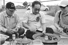  ??  ?? (From left) Stanley and Wong perform a ‘miring’ at the newly constructe­d road in Rh Lidwina while Bryan looks on.