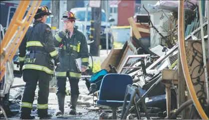  ?? ELIJAH NOUVELAGE / AGENCE FRANCE-PRESSE ?? Firefighte­rs work at the scene of the blaze in the Fruitvale neighborho­od of Oakland, California. Officials said the warehouse in which the fire broke out had been illegally converted into artists’ studios.