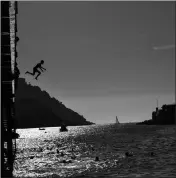  ?? ASSOCIATED PRESS ?? A BOY JUMPS FROM a platform over the water at La Concha beach during a hot summer day in the basque city of San Sebastian, northern Spain, Friday.