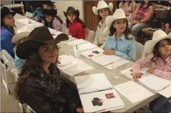  ?? PHOTO TOM BODUS ?? The 2018 Cattle Call Queen contestant­s review their binders while attending orientatio­n for the competitio­n.