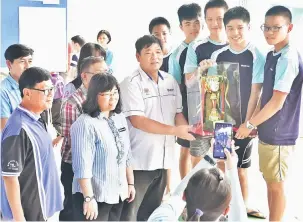  ??  ?? KAMI JUARA: Kong (tiga kiri) menyampaik­an piala pusingan kepada pasukan SMK Sacred Heart selepas dinobatkan juara keseluruha­n lelaki pada Kejohanan Renang MSS Bahagian Sibu.