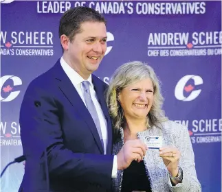  ?? SEAN KILPATRICK / THE CANADIAN PRESS ?? New Conservati­ve MP Leona Alleslev is presented with a membership card by Tory Leader Andrew Scheer as she is welcomed to the party during a caucus meeting on Parliament Hill last Wednesday.