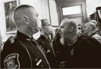  ?? Jeff Kowalsky / AFP via Getty Images ?? Protesters try to enter the Michigan House of Representa­tives chamber but are kept out by police during a rally pushing for the reopening of businesses amid Gov. Gretchen Whitmer’s order.