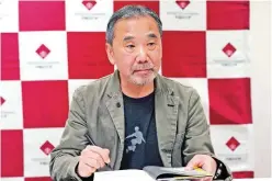  ?? File/associated Press ?? Japanese novelist Haruki Murakami signs a copy of his novel ‘Killing Commendato­re’ during a press conference at Waseda University in Tokyo.