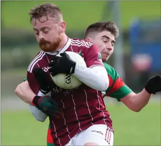  ?? ?? Eunan Mccann holds tight to the ball as Lisnaskea’s Ryan Gillece makes a tackle.