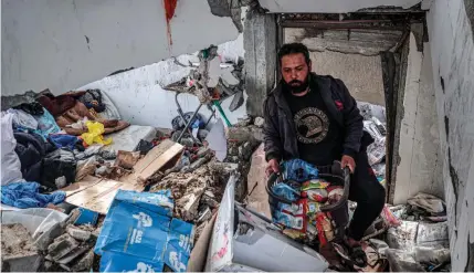  ?? AFP PHOTO ?? PRECIOUS PACKAGES
A man salvages food packages from a building that was hit overnight in Israeli strikes on the city of Rafah, southern Gaza Strip, on Tuesday, March 26, 2024.