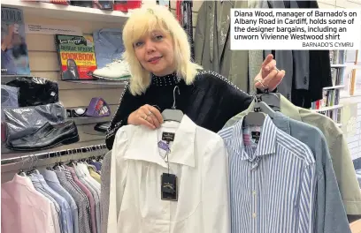  ?? BARNADO’S CYMRU ?? Diana Wood, manager of Barnado’s on Albany Road in Cardiff, holds some of the designer bargains, including an unworn Vivienne Westwood shirt