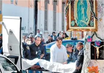  ??  ?? Peritos y policías capitalino­s retiran el cadáver de la víctima en la colonia Morelos.