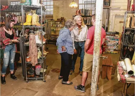  ?? Gary Fountain ?? Bob Novotney, center, owner of the Texas Junk Company, chats with Betty and Eric Cody on Saturday, when the business closed its doors after almost four decades at the same location in Montrose. Many customers lined up before the doors opened.