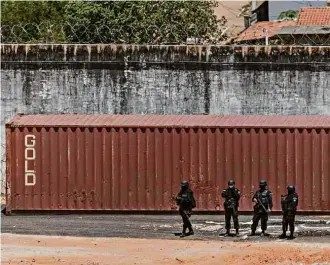  ?? Avener Prado /Folhapress ?? PMs em frente a contêiner usado para separar detentos na prisão de Alcaçuz, no RN