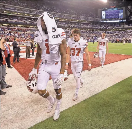  ?? MIKE DE SISTI / MILWAUKEE JOURNAL SENTINEL ?? Dejected Badgers players walk to the locker room after losing the Big Ten championsh­ip game to Penn State Saturday in Indianapol­is.