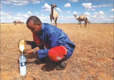  ?? ZOE TABARY / REUTERS ?? A man fills a water bottle with fresh camel milk in Hadado, Kenya, on June 30.