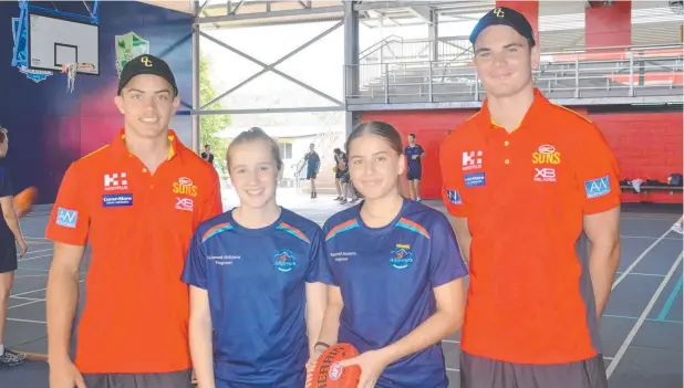  ?? Picture: ROWAN SPARKES ?? NEXT GENERATION: Gold Coast Suns players and Cairns products Caleb Graham and Jacob Heron visited St Andrew's Catholic College, giving some pointers to Piper Bentley and Sophie Christoffe­lsz, both 14, and their classmates.