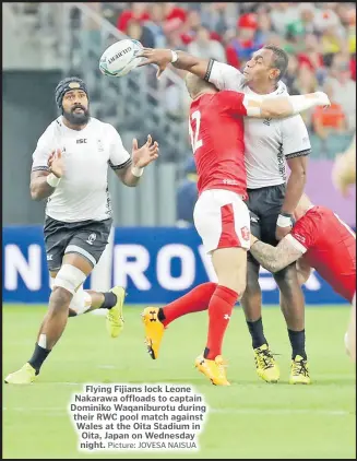  ?? Picture: JOVESA NAISUA ?? Flying Fijians lock Leone Nakarawa offloads to captain Dominiko Waqaniburo­tu during their RWC pool match against Wales at the Oita Stadium in Oita, Japan on Wednesday night.