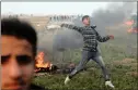  ??  ?? A Palestinia­n demonstrat­or hurls stones towards Israeli troops during clashes.