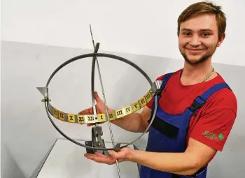  ?? MICHAEL KELLER ?? Sebastian Fricke, Azubi für Metallgest­altung im 3. Lehrjahr, mit einer in der Jugendberu­fsförderun­g für den Weihnachts­markt hergestell­ten Sonnenuhr.