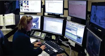  ??  ?? Dispatcher Kelly Orsini at her communicat­ions desk at the Naugatuck, Connecticu­t, Police Department. Across the country, hundreds of police agencies are checking in on seniors daily with a free automated phone call. If police can’t reach them,...