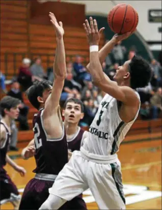  ?? RANDY MEYERS — THE MORNING JOURNAL ?? Dorian Crutcher of Elyria Catholic shoots and scores over Luke Coyne of Rocky River during the first quarter.