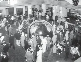  ?? Miami Herald file ?? Visitors crowd around the globe at the Pan Am seaplane terminal, now Miami’s City Hall, in Coconut Grove in the mid-1930s.