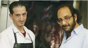  ?? (Eliyahu Kamisher) ?? FADI KATTAN (right) makes a purchase from his butcher last week for his Hosh al-Syrian guest house in Bethlehem.