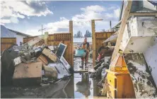  ?? JEFF MCINTOSH/ THE CANADIAN PRESS/FILES ?? Lloyd Allen helps clean up his friend's home after flooding in Princeton last November.