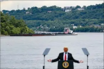  ?? JOHN MINCHILLO — THE ASSOCIATED PRESS FILE ?? In this file photo, a coal barge is positioned as a backdrop behind President Donald Trump as he speaks during a rally at the Rivertowne Marina in Cincinnati.