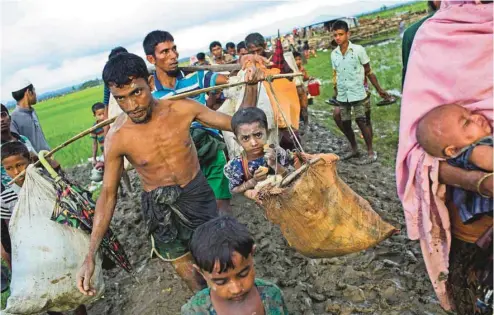  ?? BERNAT ARMANGUE ASSOCIATED PRESS ?? Des dizaines de milliers de Rohingyas ont pris la route de l’exil vers le Bangladesh voisin, à travers les rizières. Plus de 400 000 réfugiés de l’ethnie musulmane, qui ont fui de précédente­s vagues de violences, s’y trouvent déjà. Mais le Bangladesh,...