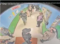  ?? Associated Press ?? Surveillan­ce video shows authoritie­s in a hallway as they respond to the shooting at Robb Elementary School in Uvalde, Texas, in May 2022. A report finds police officials demostrate­d a “lack of urgency” to set up a command post.