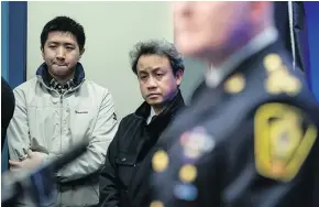  ?? — THE CANADIAN PRESS ?? Wilfred Wong, left, and Pastor Caleb Choi hear updates from police on the random shooting of Alfred Wong.