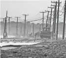  ?? PETER PEREIRA/THE STANDARD-TIMES VIA AP ?? A road is damaged after heavy winds and surf battered the coastline Jan. 10 in Westport, Mass. Massachuse­tts has been hit by severe storms.