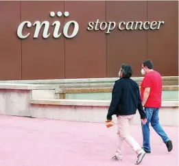  ??  ?? Dos empleados acuden a la sede del CNIO, en Madrid