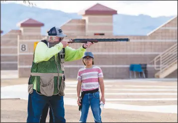  ?? BRIAN RAMOS ?? Jim Borchers, a shooting instructor and the range safety officer at the Clark County Shooting Complex, demonstrat­es how to handle a rif le for a young trapshoote­r. The Clark County Shooting Complex and the Nevada Department of Wildlife are launching a new afterschoo­l spring youth trapshooti­ng league for local middle- and high school students.